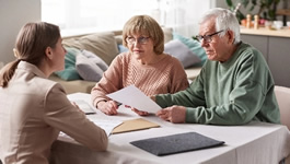 An elderly couple meeting with a representative